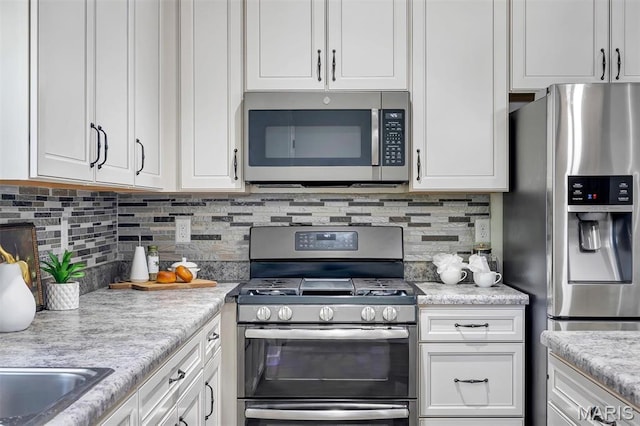153 Stella Cherry Way, Wildwood, MO 63040 - kitchen featuring appliances with stainless steel finishes, white cabinets, light countertops, and decorative backsplash
