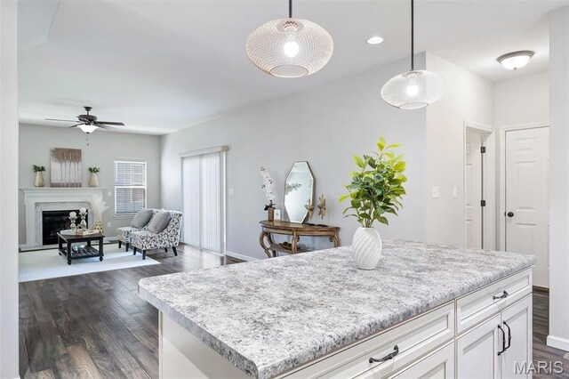 153 Stella Cherry Way, Wildwood, MO 63040 - kitchen with a ceiling fan, dark wood-type flooring, white cabinetry, hanging light fixtures, and a premium fireplace