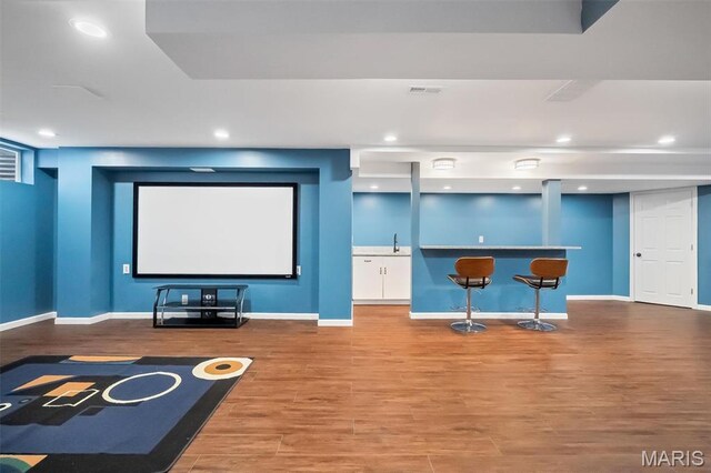 153 Stella Cherry Way, Wildwood, MO 63040 - home theater featuring bar with sink, wood finished floors, baseboards, and recessed lighting