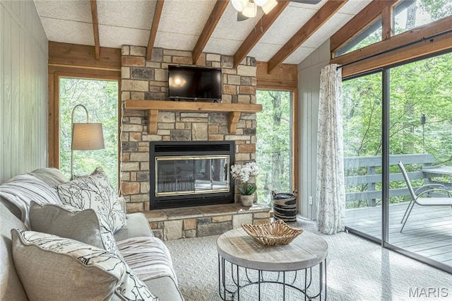 1235 Powderhorn Dr, Innsbrook, MO 63390 - carpeted living room featuring wood walls, a ceiling fan, a stone fireplace, and plenty of natural light