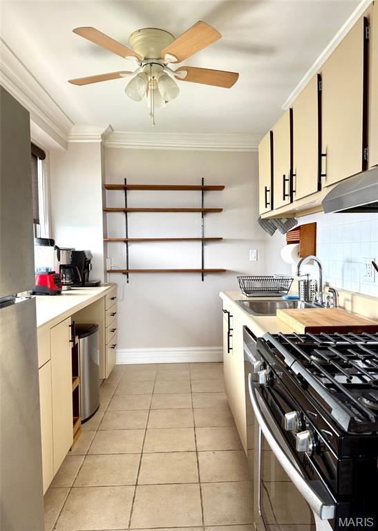 4466 W Pine Blvd Unit 22F, Saint Louis, MO 63108 - kitchen featuring a sink, light countertops, stainless steel gas stove, baseboards, and ornamental molding