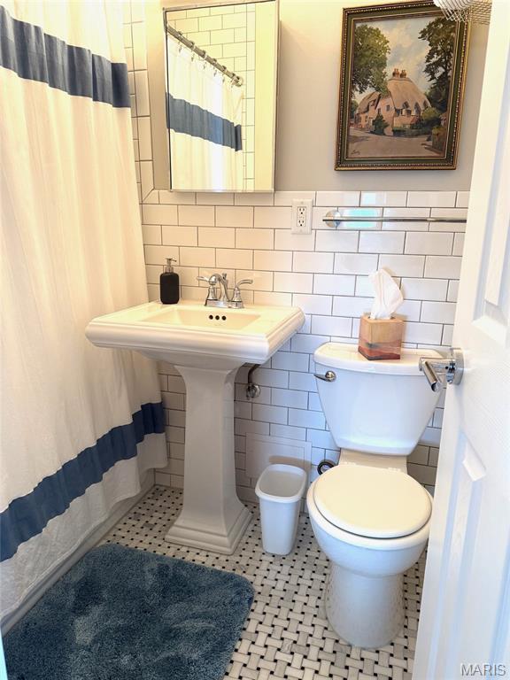 4466 W Pine Blvd Unit 22F, Saint Louis, MO 63108 - full bath featuring tile walls, toilet, tile patterned flooring, and a shower with shower curtain