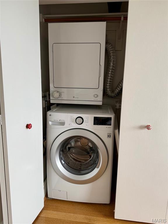 4466 W Pine Blvd Unit 22F, Saint Louis, MO 63108 - clothes washing area featuring stacked washer / dryer and light wood-style flooring