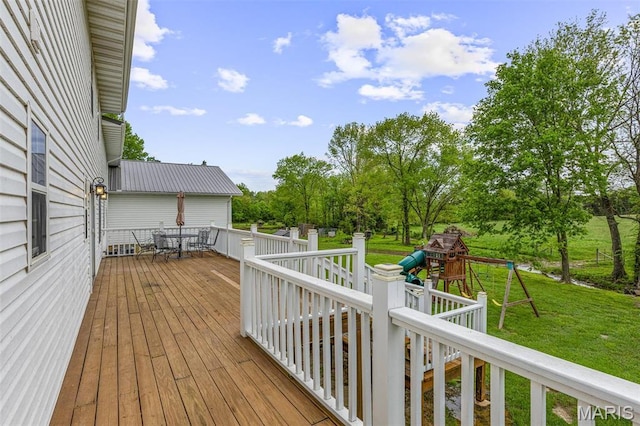 802 Hager Rd, Farmington, MO 63640 - wooden terrace with a playground, a lawn, outdoor dining space, and view of wooded area
