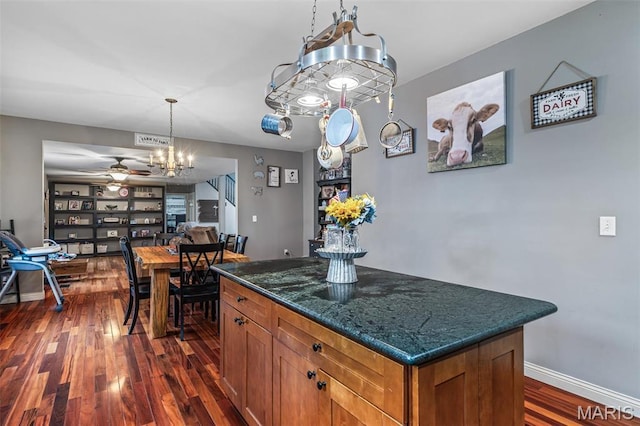 802 Hager Rd, Farmington, MO 63640 - kitchen with dark wood-style flooring, brown cabinetry, ceiling fan, a center island, and pendant lighting