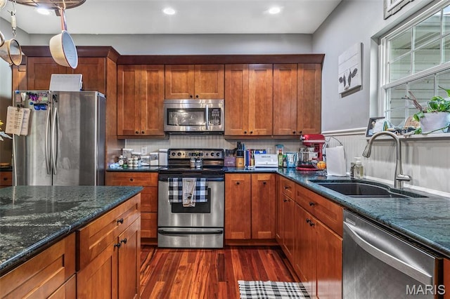 802 Hager Rd, Farmington, MO 63640 - kitchen featuring appliances with stainless steel finishes, a sink, dark wood-style floors, brown cabinetry, and dark stone counters