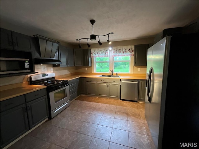 305 Pine Grove Rd, Willow Springs, MO 65793 - kitchen with stainless steel appliances, gray cabinetry, a sink, under cabinet range hood, and light countertops