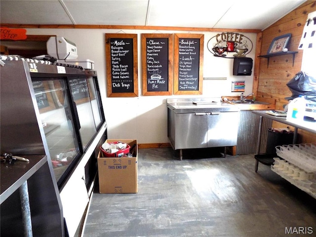 491 Broadway St, Edgar Springs, MO 65462 - kitchen featuring stainless steel dishwasher, a sink, wood finished floors, open shelves, and wooden walls