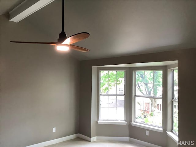 spare room with a ceiling fan, baseboards, and vaulted ceiling