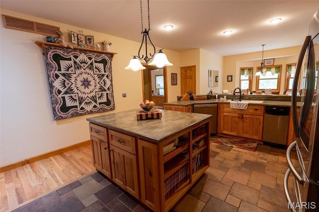 14035 County Road 4110, Rolla, MO 65401 - kitchen featuring appliances with stainless steel finishes, a sink, dark countertops, brown cabinetry, and pendant lighting