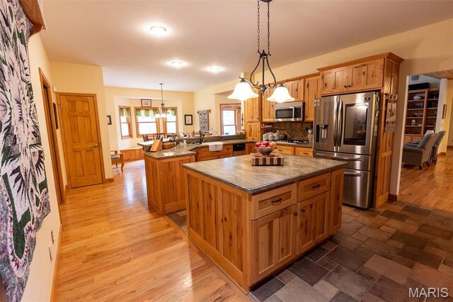 14035 County Road 4110, Rolla, MO 65401 - kitchen featuring stainless steel appliances, a peninsula, a chandelier, a center island, and decorative light fixtures