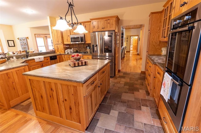14035 County Road 4110, Rolla, MO 65401 - kitchen featuring stainless steel appliances, a center island, glass insert cabinets, brown cabinets, and dark stone finish flooring