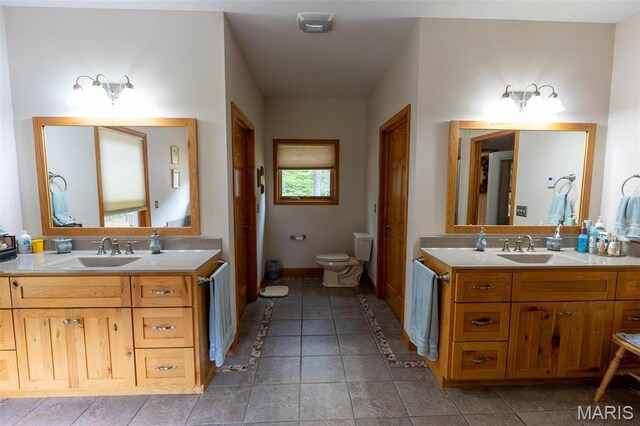 14035 County Road 4110, Rolla, MO 65401 - full bath featuring two vanities, toilet, tile patterned flooring, and baseboards