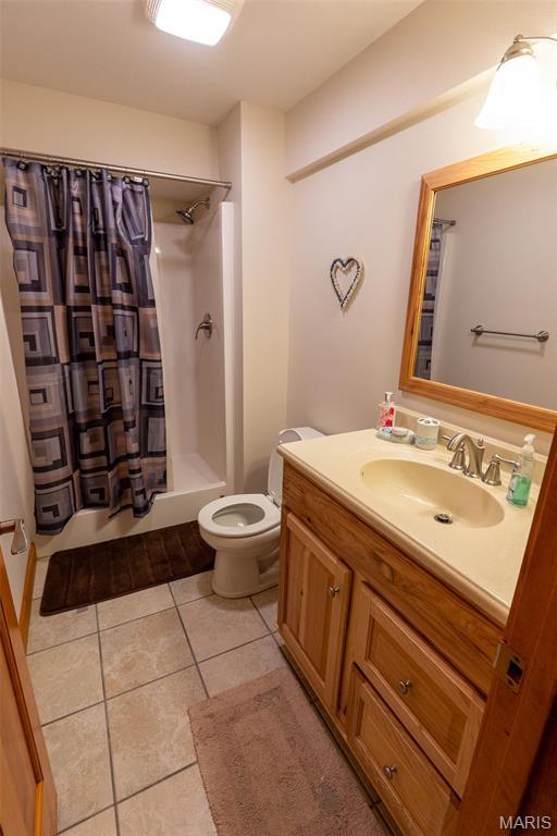 14035 County Road 4110, Rolla, MO 65401 - full bathroom featuring a shower with shower curtain, tile patterned flooring, toilet, and vanity