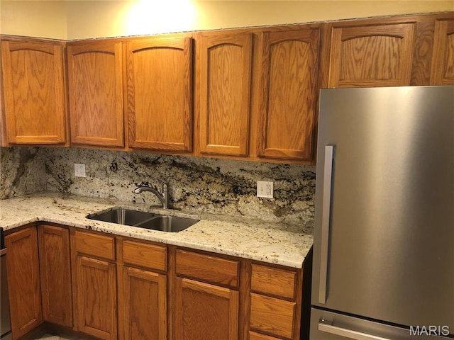 4501 San Francisco, San Francisco, Saint Louis, MO 63115 - kitchen featuring freestanding refrigerator, decorative backsplash, light stone countertops, and brown cabinets