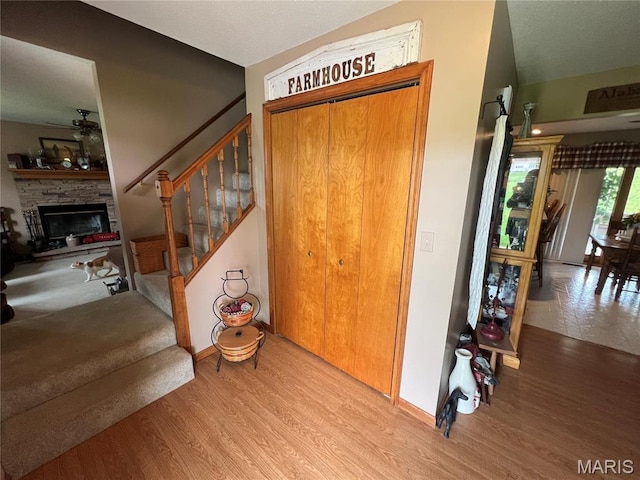 7070 Goldenrod Rd, Hannibal, MO 63401 - foyer entrance with stairway, wood finished floors, a ceiling fan, and a fireplace