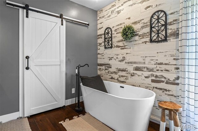 162 Saint Benedict, Pevely, MO 63070 - bathroom with a freestanding tub, wood finished floors, wooden walls, an accent wall, and baseboards