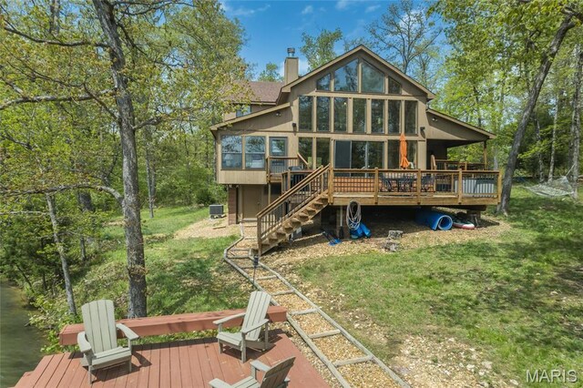 2635 Grendel Rdg, Innsbrook, MO 63390 - rear view of house featuring a sunroom, a wooden deck, a chimney, a yard, and stairway