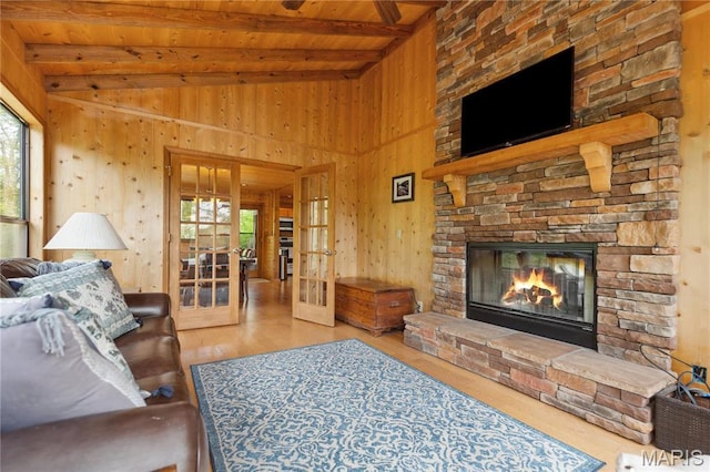 2635 Grendel Rdg, Innsbrook, MO 63390 - living area with wooden ceiling, plenty of natural light, wooden walls, a stone fireplace, and wood finished floors