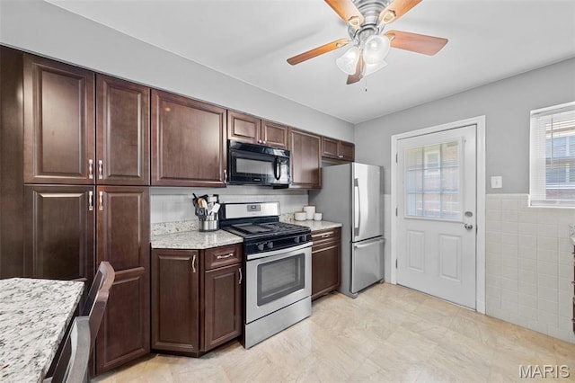 8452 S Laclede Station Rd, Saint Louis, MO 63123 - kitchen with appliances with stainless steel finishes, tile walls, dark brown cabinets, ceiling fan, and wainscoting