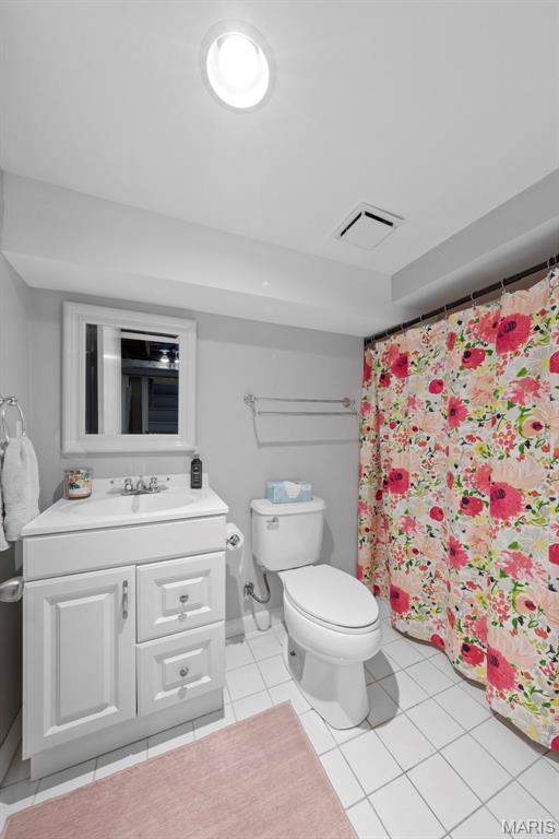8452 S Laclede Station Rd, Saint Louis, MO 63123 - full bathroom featuring toilet, tile patterned flooring, vanity, and curtained shower