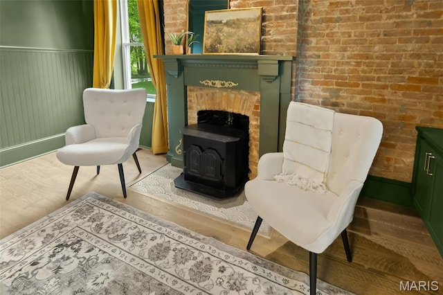 2367 Central Ave, Alton, IL 62002 - sitting room with a wood stove, a wainscoted wall, wood finished floors, and brick wall