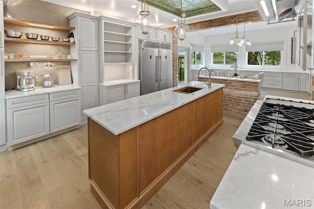 2367 Central Ave, Alton, IL 62002 - kitchen featuring stainless steel appliances, a sink, open shelves, light wood-style flooring, and beamed ceiling