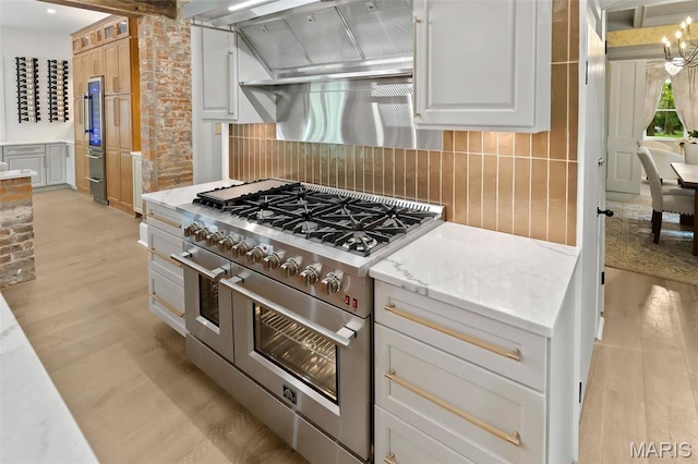 2367 Central Ave, Alton, IL 62002 - kitchen featuring range with two ovens, light wood-style floors, white cabinetry, and exhaust hood