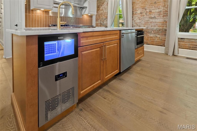 2367 Central Ave, Alton, IL 62002 - kitchen featuring baseboards, light wood-style floors, appliances with stainless steel finishes, a sink, and light countertops