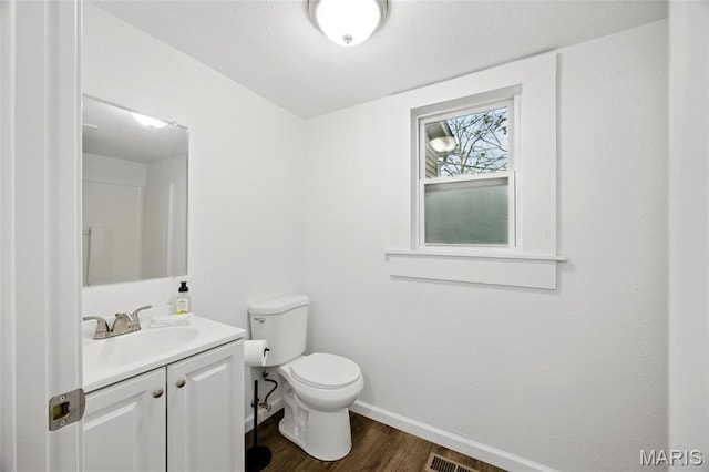 202 N Thomas St, De Soto, MO 63020 - bathroom with wood finished floors, toilet, vanity, and baseboards