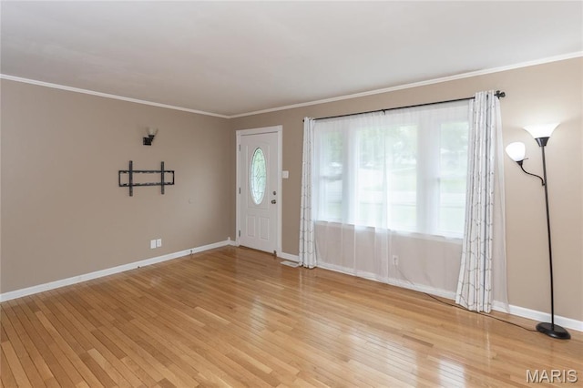 foyer entrance with light wood-type flooring, baseboards, and crown molding