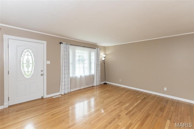 foyer with plenty of natural light, baseboards, light wood finished floors, and ornamental molding