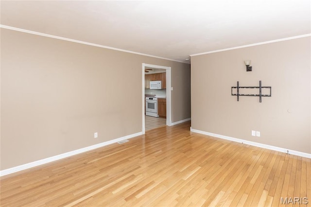 unfurnished room featuring light wood finished floors, baseboards, and ornamental molding