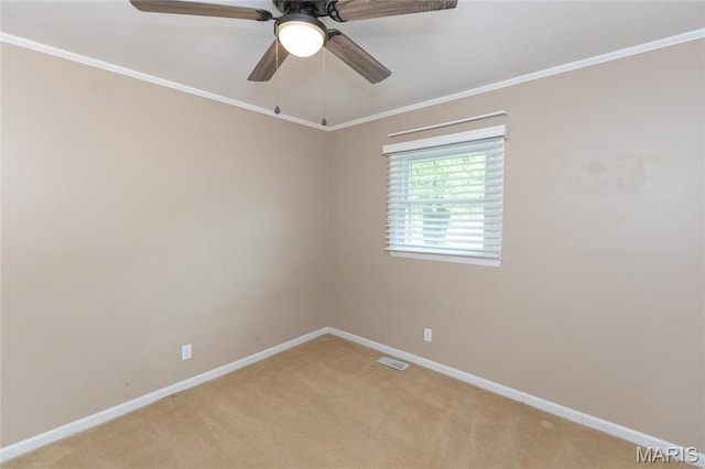 spare room featuring baseboards, light carpet, a ceiling fan, and ornamental molding