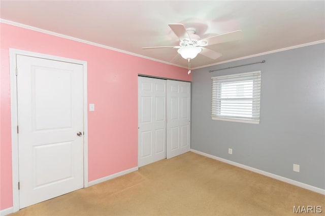 unfurnished bedroom featuring light carpet, baseboards, crown molding, a closet, and ceiling fan