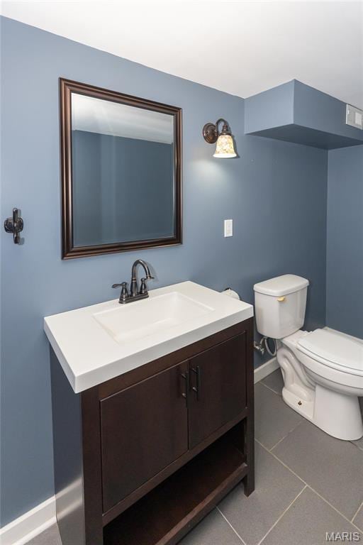 half bathroom featuring toilet, vanity, tile patterned floors, and baseboards