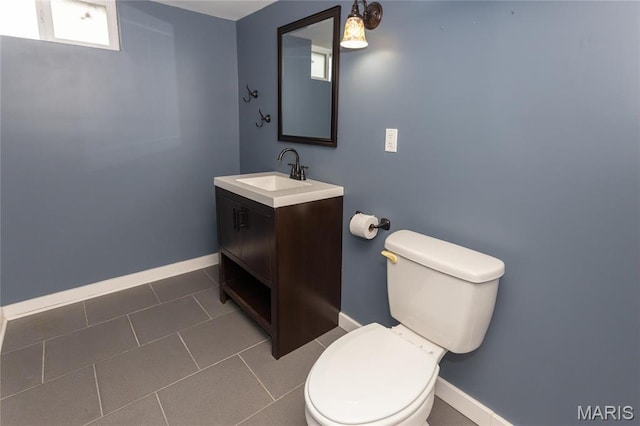 half bathroom with baseboards, toilet, vanity, and tile patterned flooring