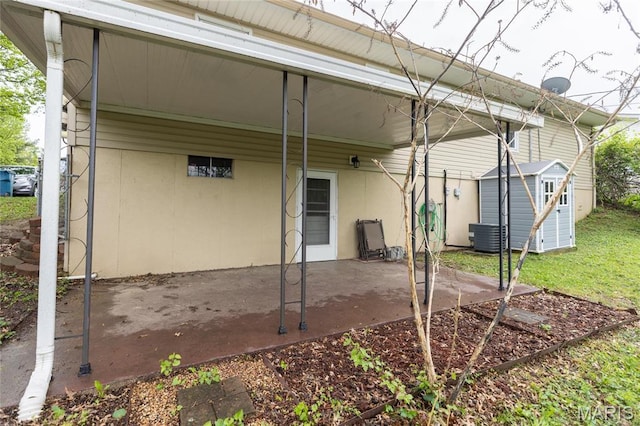 rear view of house featuring a shed, a patio, an outbuilding, an attached carport, and central air condition unit