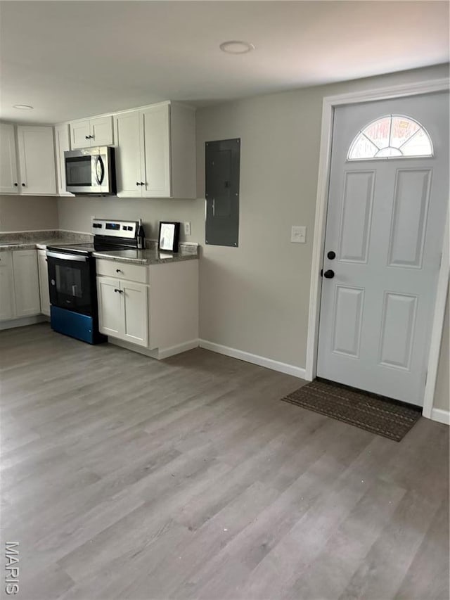 229 Siebenman St, Bourbon, MO 65441 - kitchen featuring appliances with stainless steel finishes, electric panel, baseboards, light wood-style floors, and white cabinetry