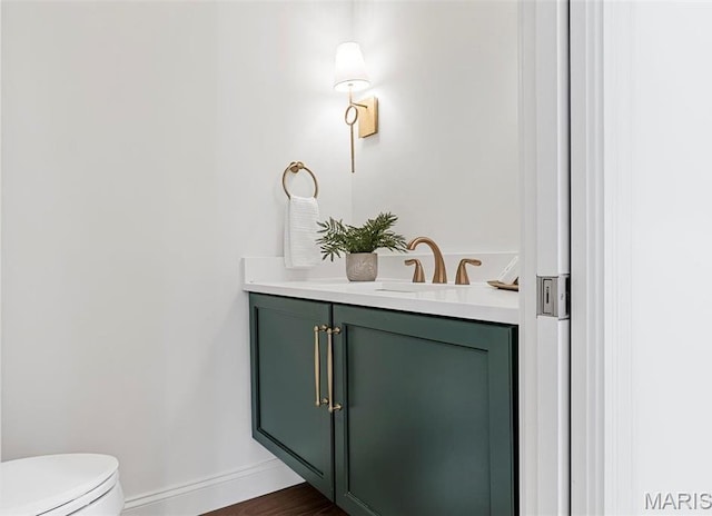 bathroom featuring vanity, baseboards, toilet, and wood finished floors