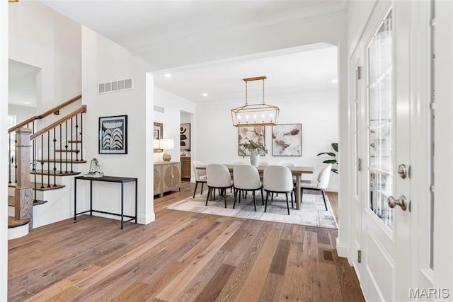 dining area with wood finished floors, stairs, ornamental molding, baseboards, and recessed lighting