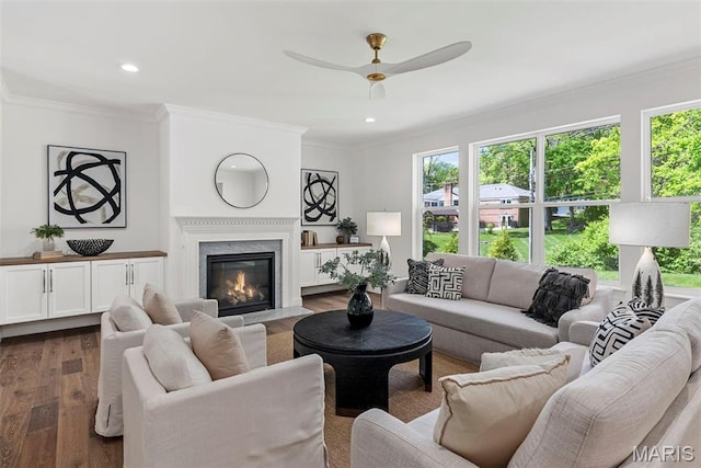 living area with dark wood-style flooring, a ceiling fan, plenty of natural light, crown molding, and recessed lighting