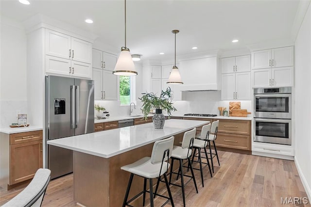 kitchen featuring stainless steel appliances, light wood-style flooring, tasteful backsplash, recessed lighting, and a breakfast bar
