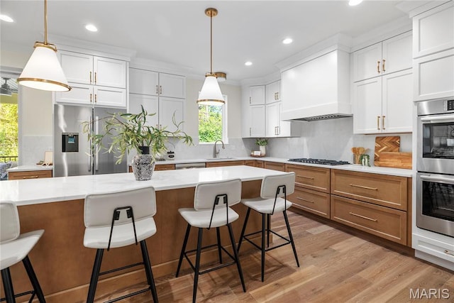 kitchen featuring stainless steel appliances, a sink, recessed lighting, light wood-style floors, and backsplash