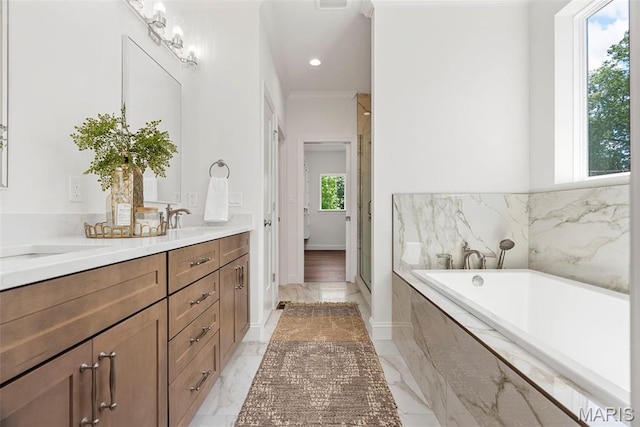 full bathroom featuring marble finish floors, vanity, a bath, a stall shower, and ornamental molding