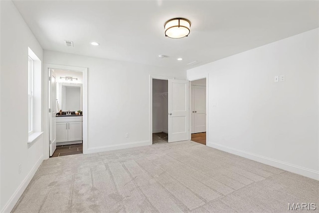 unfurnished bedroom with carpet floors, baseboards, a spacious closet, and recessed lighting