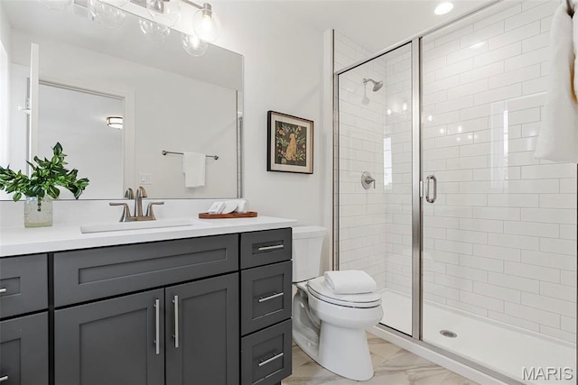 full bathroom featuring marble finish floors, a shower stall, toilet, and vanity