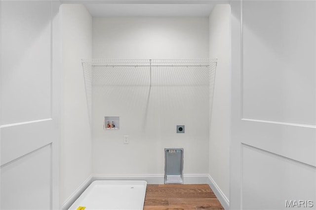 clothes washing area with washer hookup, hookup for an electric dryer, wood finished floors, and baseboards