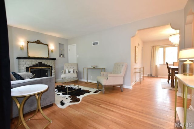 living room with wood finished floors, a fireplace, and baseboards