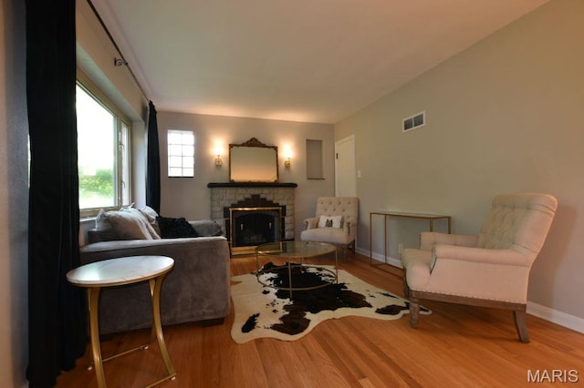 living area with wood finished floors, a fireplace, and baseboards